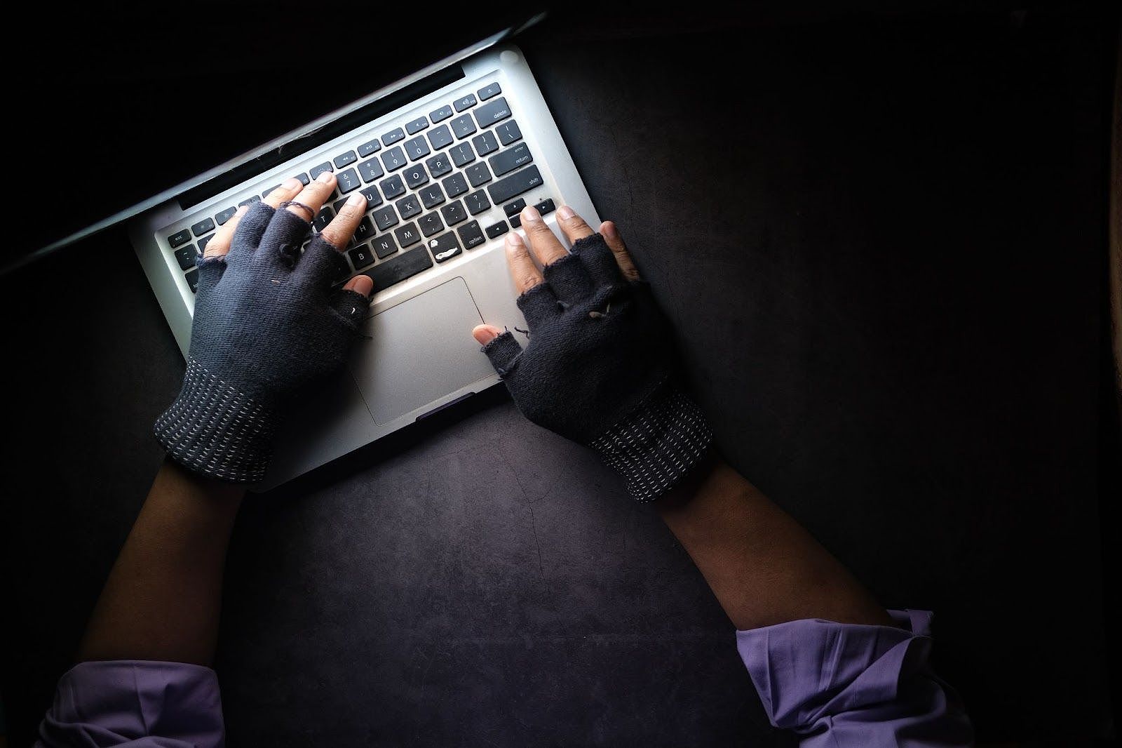 Hacker typing on a laptop